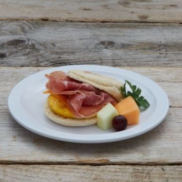English Muffin Breakfast Sandwich served with Egg Patty, Cheddar and Prosciutto with Fruit