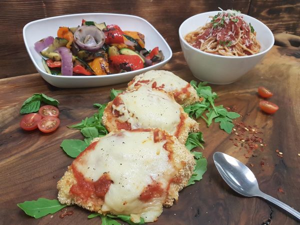 Chicken Parmigiana served with Pasta and Grilled Vegetables.